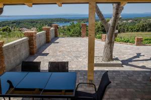a table and chairs on a patio with a view at VILLA LIDIA in Mundanije