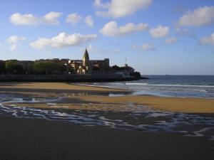 a view of a beach with a building and the ocean at Hotel Costa Verde in Gijón