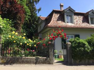 a house with a fence with red flowers at Bed and Breakfast Wildrose in Bern