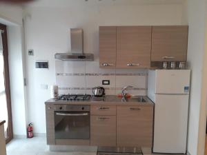 a kitchen with a stove and a refrigerator at Casa della nonna per voi parcheggio gratuito condizionatore portatile CIR 0052 in Aosta