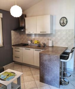 a kitchen with white cabinets and a counter top at Apartment Ben in Pula