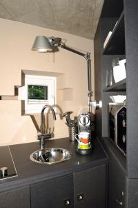 una cucina con lavandino e lampada sul bancone di Au Bunker 67 a Rott