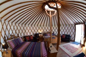 a room with a bed and chairs in a yurt at Doolin Glamping in Doolin