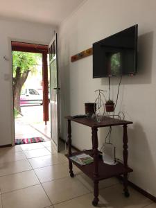 Habitación con TV en la pared y mesa. en la casita de colonia 1, en Colonia del Sacramento