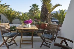 a table and chairs on a balcony with palm trees at El Marinero in Puerto del Carmen