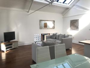 a living room with a couch and a tv at Ice House Apartments in Swansea
