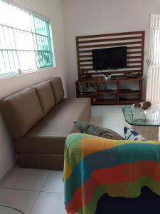 a living room with a couch and a flat screen tv at Aconchego dos Milagres in São Miguel dos Milagres