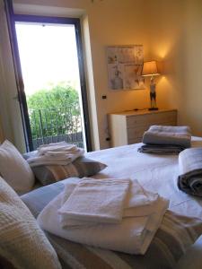 een slaapkamer met 2 bedden en handdoeken bij Garda Dreams Apartment in Torri del Benaco
