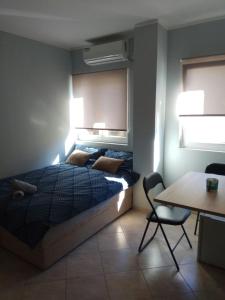 a bedroom with a bed and a table and a chair at Apartmani MiNa in Neum