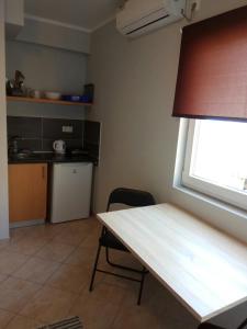 a table and a chair in a kitchen with a window at Apartmani MiNa in Neum +12 photos