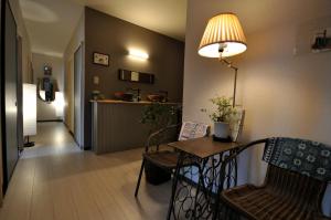 uma sala de estar com uma mesa e cadeiras e um corredor em Chambre dhote Tatami em Suwa