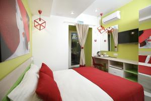 a bedroom with a red and white bed and a desk at Hotel Raduga in Krasnoyarsk