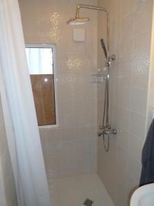 uma casa de banho com um chuveiro e uma porta de vidro em Red Door Apartment em Sófia