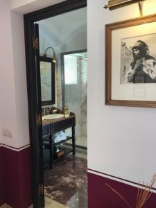 uma casa de banho com um espelho e um lavatório em Heure Bleue Palais - Relais & Châteaux em Essaouira