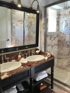 a bathroom with two sinks and a large mirror at Heure Bleue Palais - Relais & Ch&acirc;teaux in Essaouira