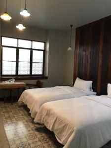 a room with three beds with white sheets at Thaimueang Boutique Hotel in Thai Muang
