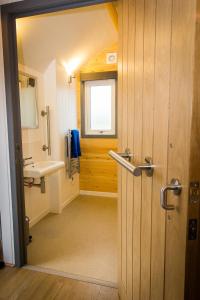 a bathroom with a sink and a toilet and a window at Evelix Pods Dornoch in Dornoch