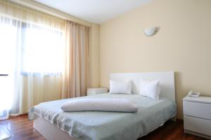 a bedroom with a white bed with a window at Sara in Vama Veche