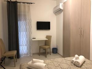 Un dormitorio con una cama, un escritorio y un televisor. en STABILE139, en Palermo