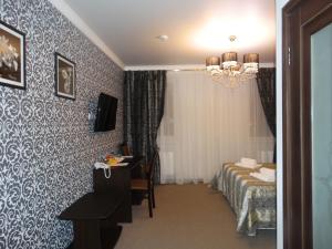 a hotel room with a bed and a table and a window at Guest house Pridvorov in Krasnodar