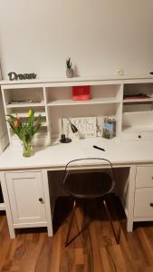 Un escritorio blanco con un jarrón de flores. en Familienzimmer in Kassel en Kassel