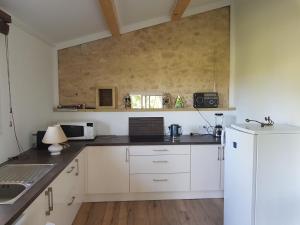 a kitchen with white cabinets and a white refrigerator at Gîte à la ferme in Upie