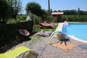 a backyard with a pool with chairs and a water slide at Gîte à la ferme in Upie