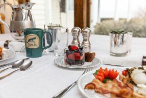 a table with plates of food on a table at Spouter Inn Bed & Breakfast in Lincolnville +99 photos