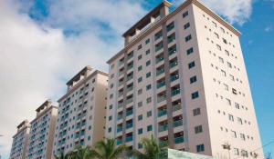 a tall white building with palm trees in the foreground at SALINAS PARK RESORT - Melhor Resort do Norte in Salinópolis