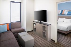 a living room with a couch and a flat screen tv at Hyatt House Nashville at Vanderbilt in Nashville