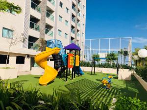 - une aire de jeux avec toboggan jaune dans la cour dans l'établissement SALINAS PARK RESORT - Melhor Resort do Norte, à Salinópolis