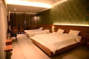 een slaapkamer met 2 bedden en een wachtkamer bij The Bliss Hotel in Somnath