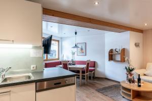 a kitchen and living room with a couch and a table at Appartement Mangeng in Bartholomäberg