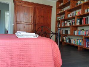 a bedroom with a bed with a red blanket and book shelves at B&B Le Mura in Grosseto