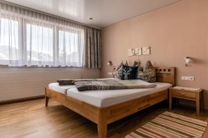 um quarto com uma cama grande e uma janela em Appartement Mangeng em Bartholomäberg