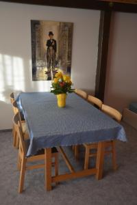 une table avec un chiffon de table bleu et un vase de fleurs dans l'établissement Familienzimmer Bastian, à Haibach