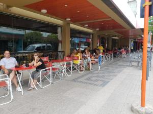 a group of people sitting at tables outside a restaurant at HOTEL CONTINENTAL COSQUIN in Cosquín