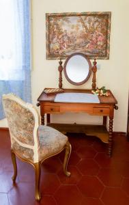 a dressing table with a mirror and a chair at Villa Antiche Mura in Empoli