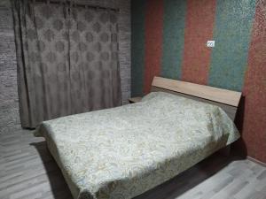 Cama pequeña en habitación con pared en Milo Apart Hotel, en Karagandá