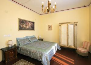 a bedroom with a bed and a chandelier and a chair at Villa Antiche Mura in Empoli
