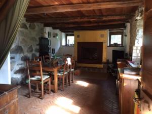 una sala da pranzo con tavolo e camino in pietra di Bellissimo Rustico A 7 km Dal Lago D'Orta a Omegna