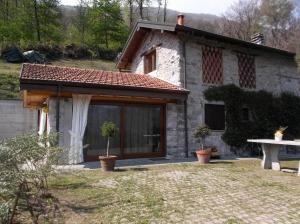 kamienny dom z dużym oknem i stołem w obiekcie Bellissimo Rustico A 7 km Dal Lago D'Orta w mieście Omegna +11 zdjęć