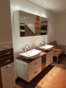 a bathroom with two sinks and a large mirror at Montafon Alpen Chalet in Vandans +27 photos