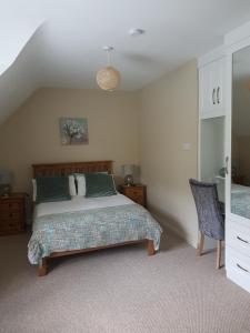 um quarto com uma cama e uma cadeira em Woodview Bed & Breakfast. em Letterkenny