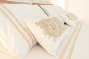 a row of white pillows on a bed at Via Dante Luxury Home in Bari
