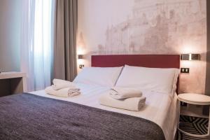 a bedroom with a bed with towels on it at Hotel Cannaregio 2357 in Venice