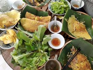 a table topped with plates of food and salad at Tien Yoga House in Cái Bè +31 photos