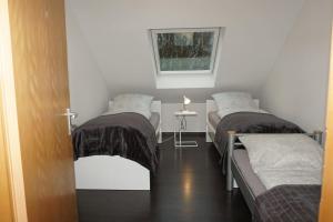 a room with two beds and a table with a window at Haus Rodriguez in Baesweiler
