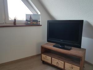 TV de pantalla plana en la parte superior de un soporte de madera en DOMizil Xanten, en Xanten