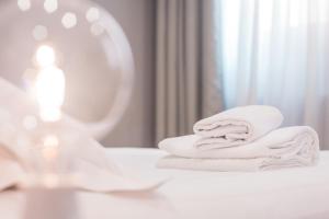 a stack of towels on a bathroom counter in front of a mirror at Hotel Cannaregio 2357 in Venice